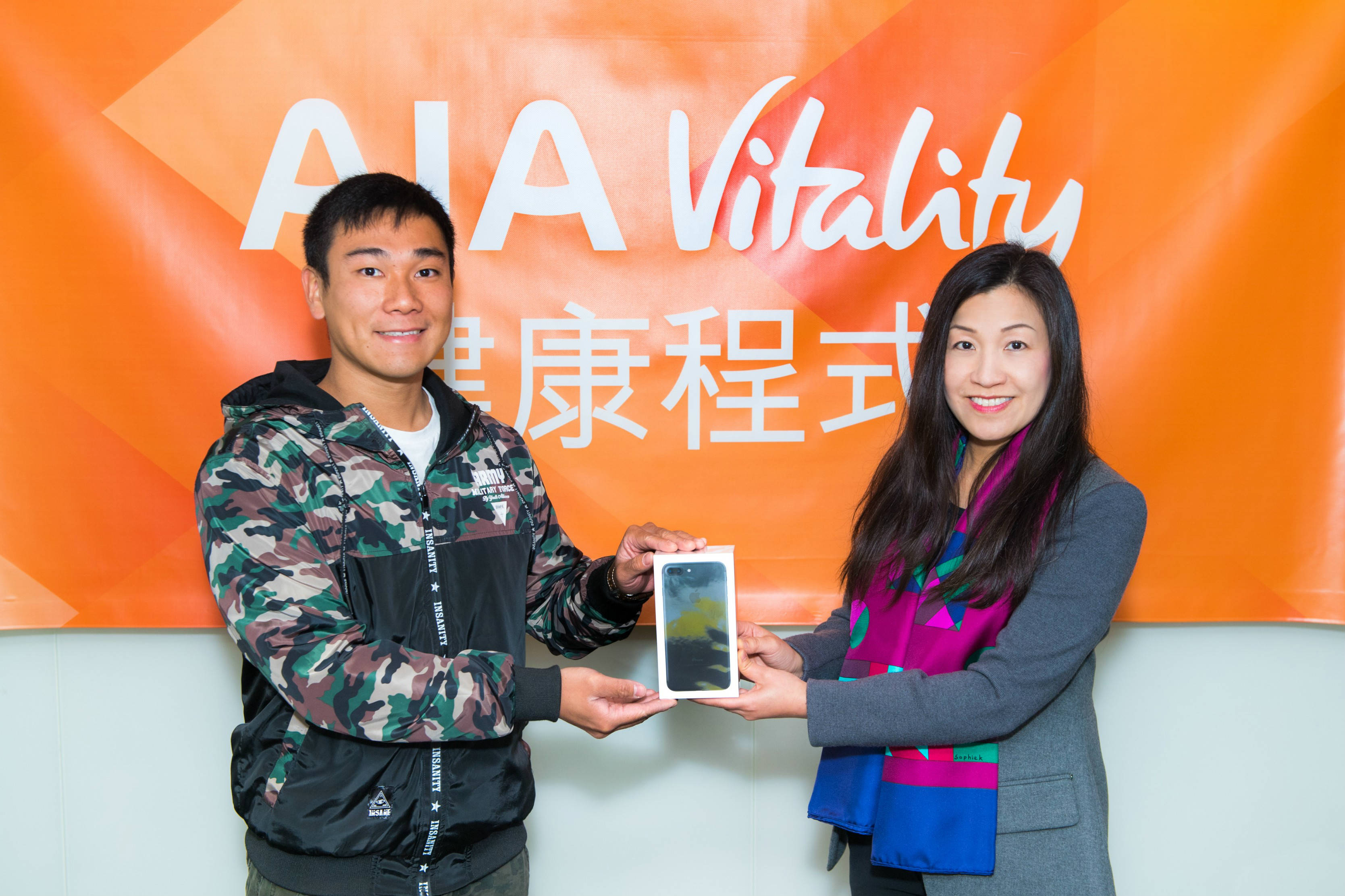 Ms Bonnie Tse, General Manager, Business Strategy and Marketing of AIA Hong Kong & Macau (right) presents the latest smartphones to the two winners of the first week's AIA Vitality Weekly Challenge Lucky Draw.